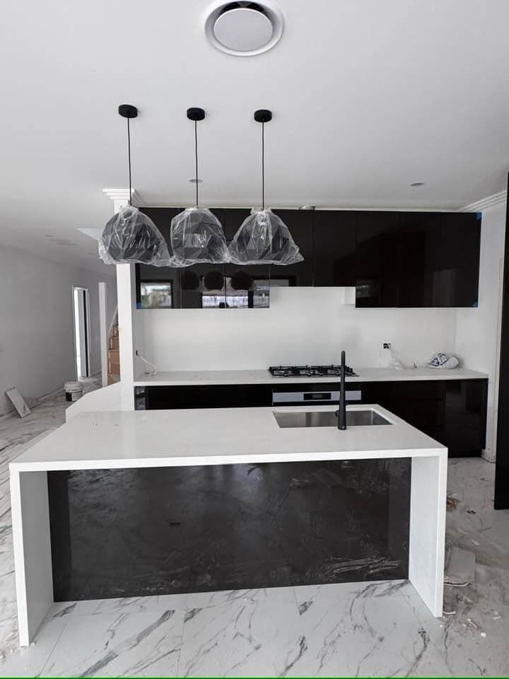 Finished black gloss kitchen with a stone island