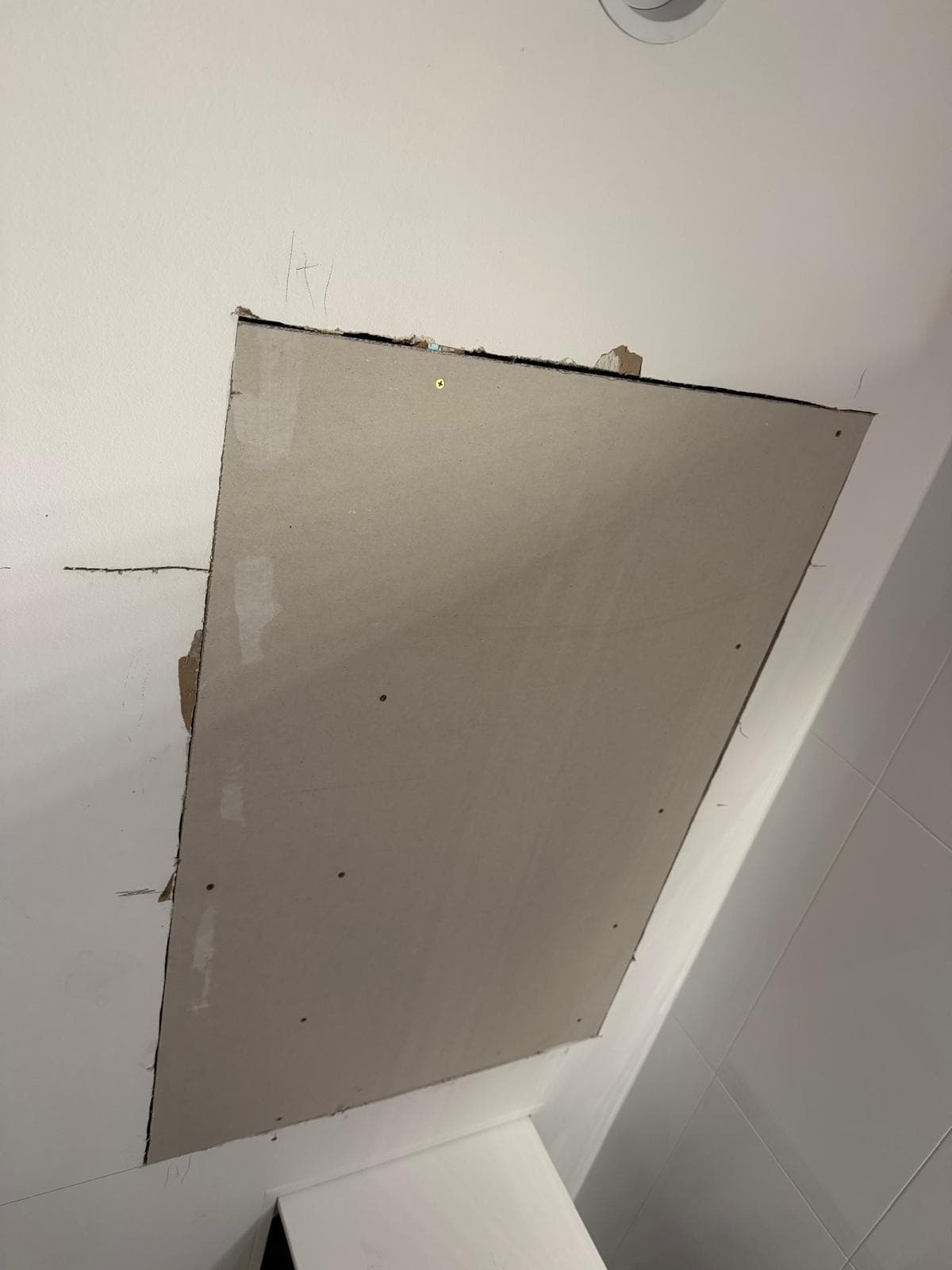 New plasterboard sheet fixed into a repaired ceiling