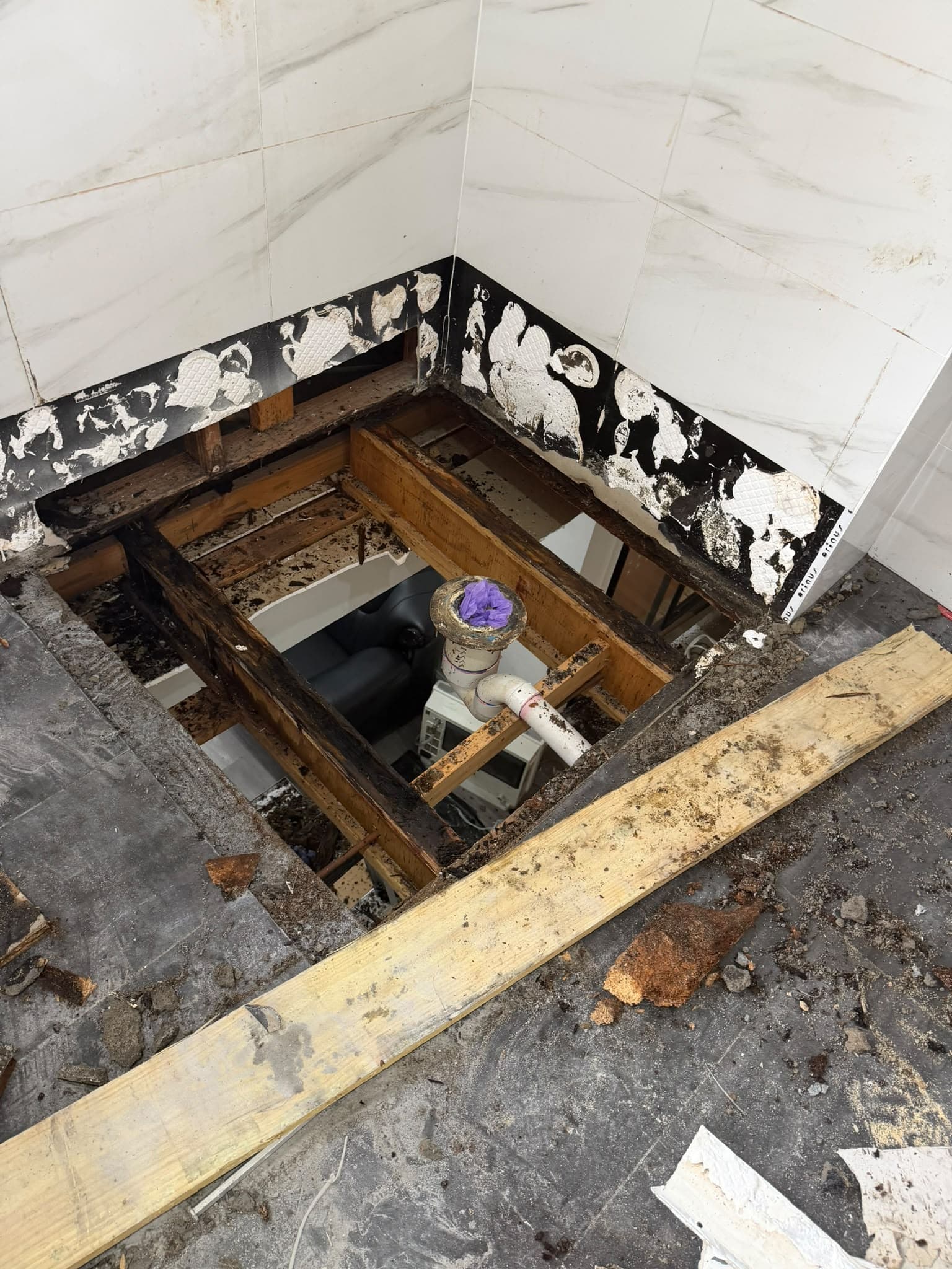 Water-damaged bathroom floor joists exposed