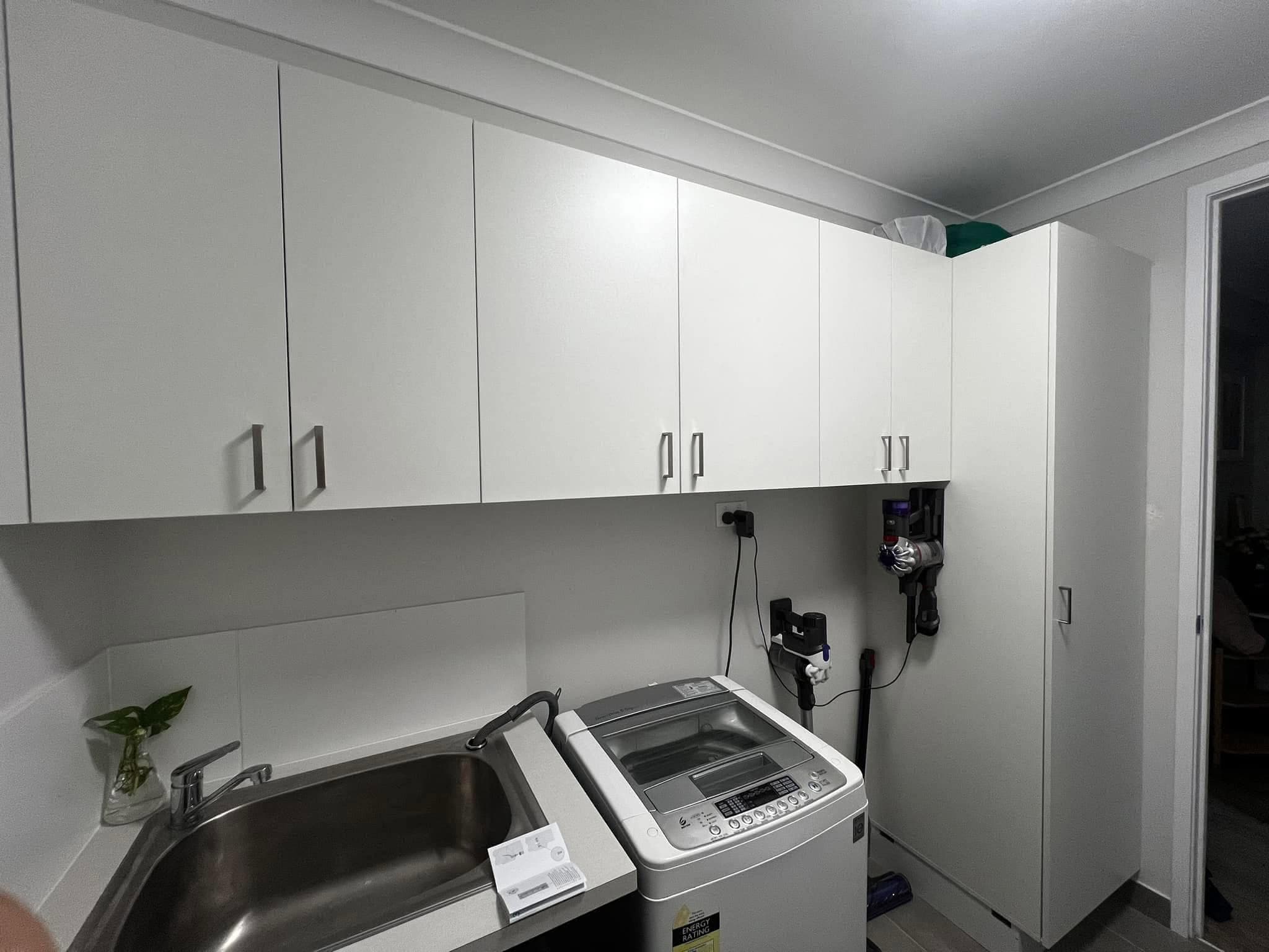 Finished laundry with overhead cabinets and trough
